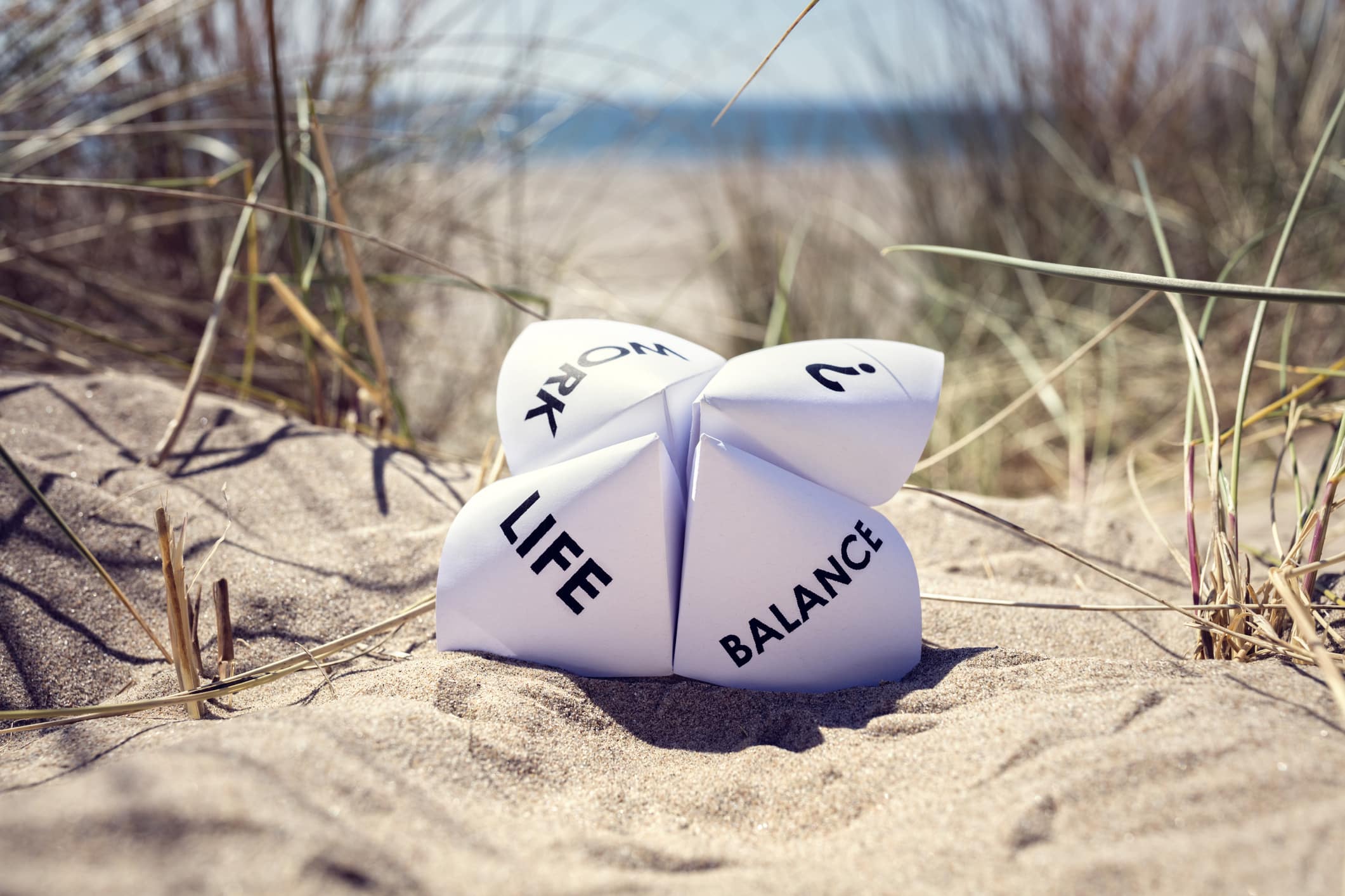 Origami fortune teller on vacation at the beach concept for work life balance choices