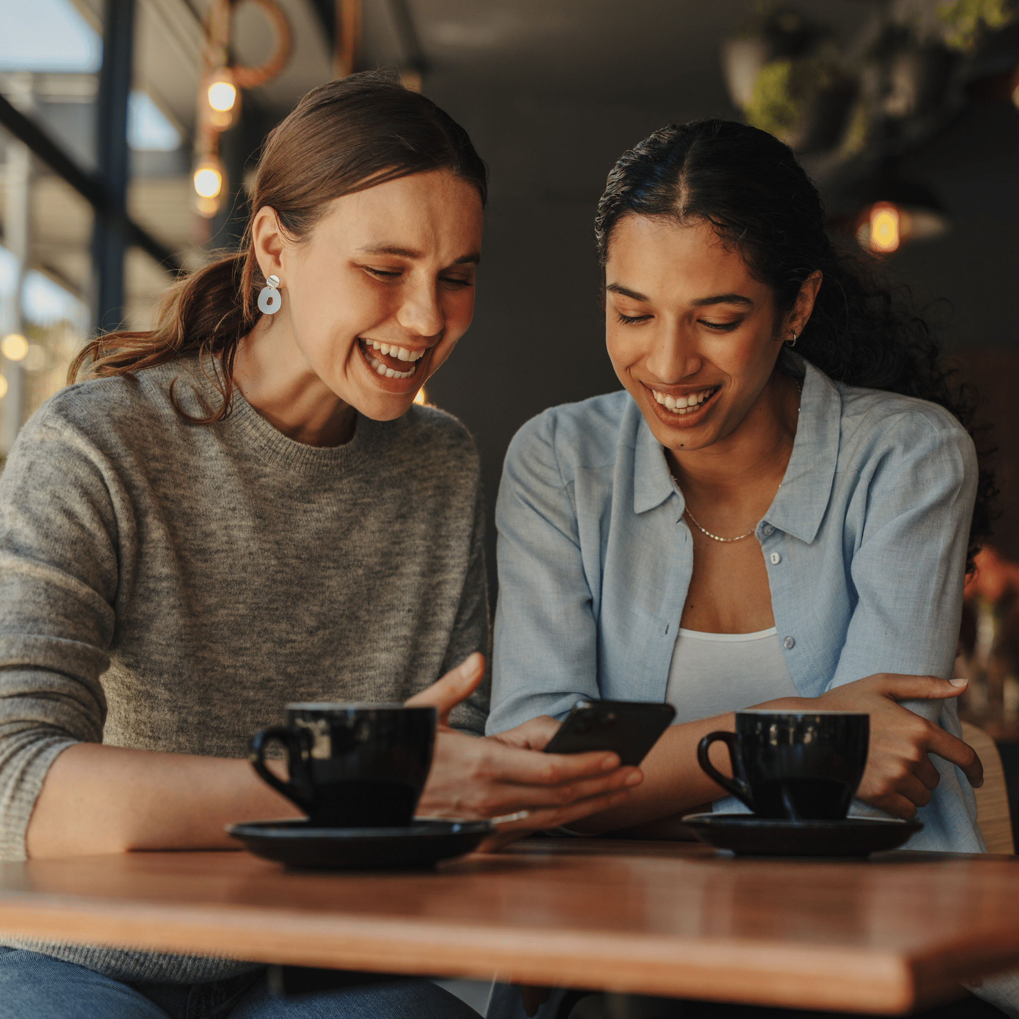 Female showing to her friend something on her phone